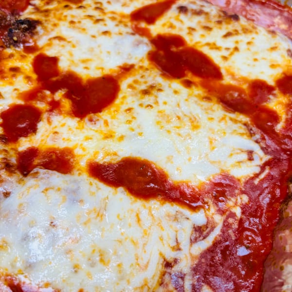 Close-up of a baked lasagna with melted cheese and rich red tomato sauce from Casa D'angelo.
