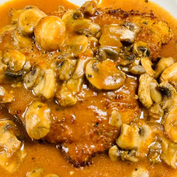 Close-up of a Casa D'angelo Italian dish with chicken or veal in a rich mushroom sauce.